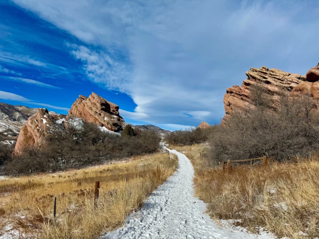 Snowy trail leading between red rock formations