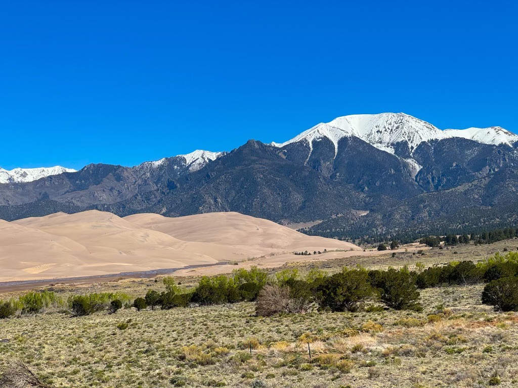 landscape of sand dunes with mountains in the background